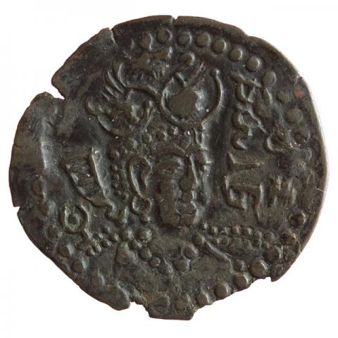 Büste mit geflügelter Löwenkopf-Stierkopf-Krone und Stirnsichel in ¾-Ansicht, links Tamga; Brahmi-Legende „Seine Exzellenz Ranasrikari“