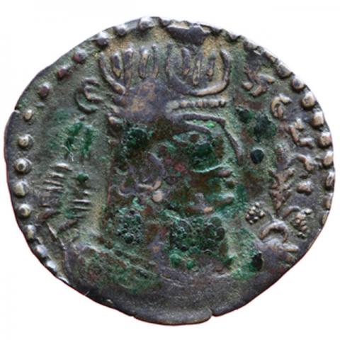 Bekrönte Büste mit Turmschädel, in der Rechten Bündel aus drei Pflanzen haltend; Brahmi-Aufschrift „Seine Exzellenz, König Tora“